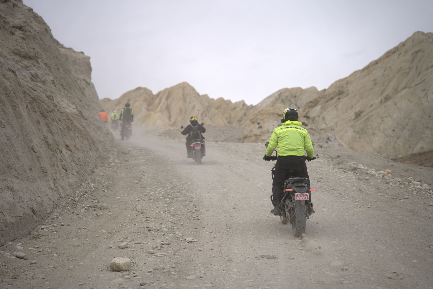A group riding motorcycle in dust and wind on their way to upper mustang from kagbeni